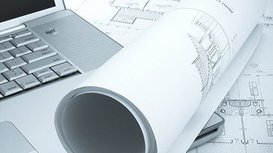 Bauzeichnungen und ein Laptop